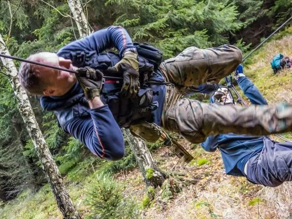Person schwingt an Seil durch den Wald beim Überlebenstraining