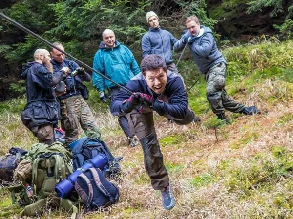 Person zieht an einem Seil, während andere zuschauen beim Survival Training