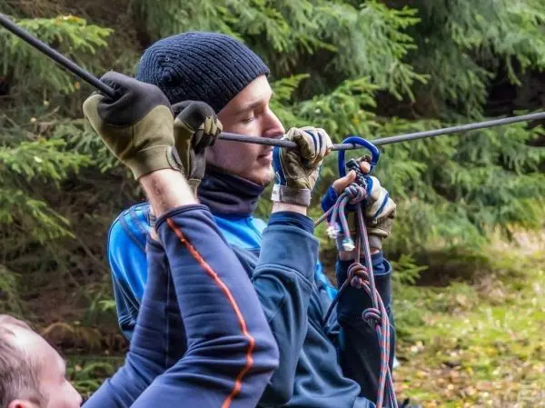 Seilquerung mit Karabiner und Seil, Person zieht sich nach oben
