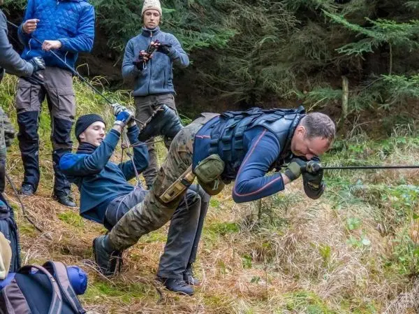 Seilquerung mit selbstgebauter Seilbrücke durch Teilnehmer im Wald