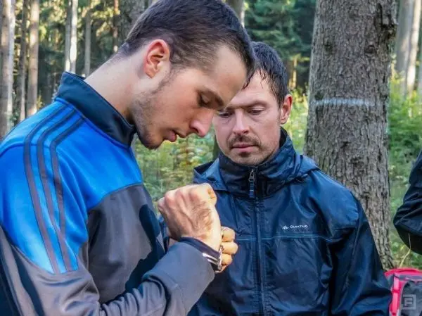 Zwei Personen betrachten eine Ausrüstung im Wald