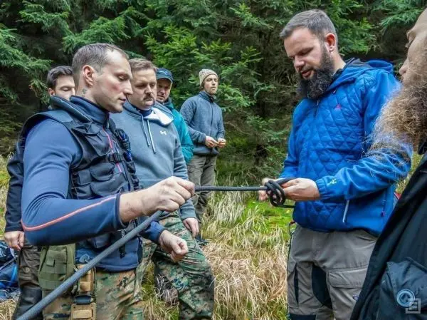 Zwei Personen binden ein Seil, während andere zuschauen