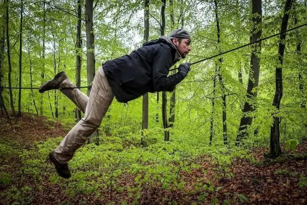 Selbstgebaute Seilquerung wird von einer Person überquert