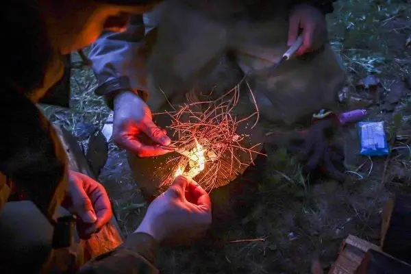 Zunder glimmt, während Feuerstahl Funken erzeugt