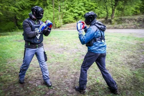 Zwei Personen im Boxkampf tragen Schutzausrüstung und Boxhandschuhe