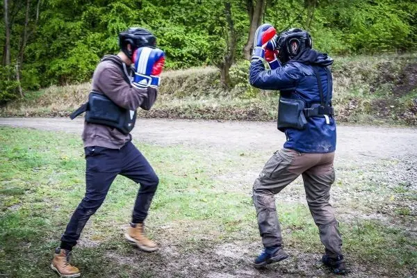 Zwei Personen im Boxkampf tragen Schutzausrüstung und Boxhandschuhe