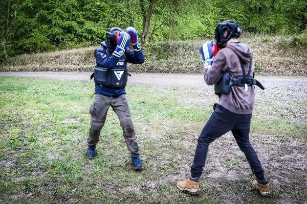 Zwei Personen im Boxkampf tragen Schutzausrüstung und Boxhandschuhe