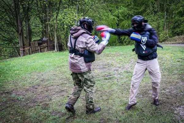 Zwei Personen im Boxkampf tragen Schutzausrüstung und Boxhandschuhe