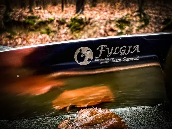 Klinge mit eingraviertem Logo und Schriftzug auf reflektierender Oberfläche