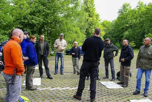 Gruppe hört einem Referenten im Freien aufmerksam zu