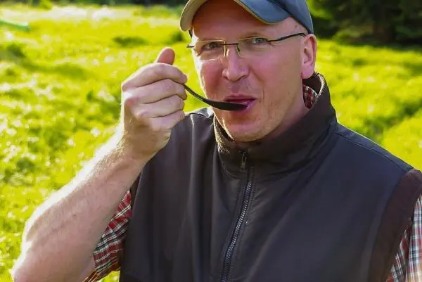 Mann mit Löffel in der Hand kostet eine Speise im Freien