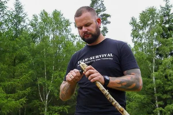 Messer bearbeitet einen Stock im Wald