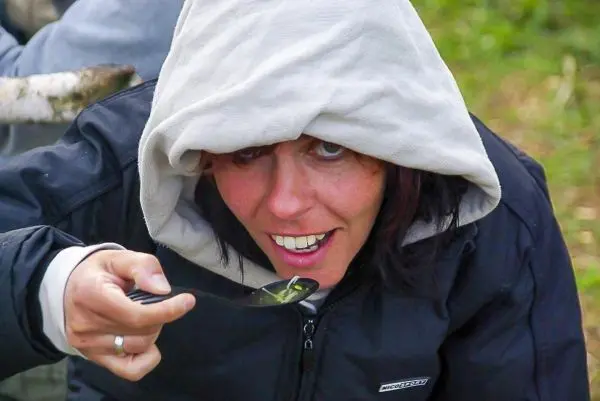Person hält einen Löffel mit Essen in der Hand