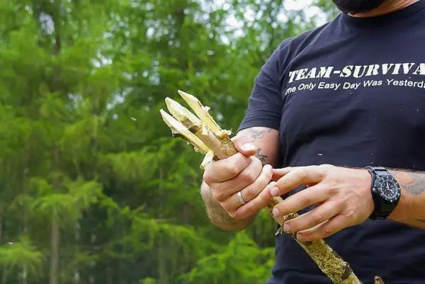 Person schnitzt einen Stock im Wald