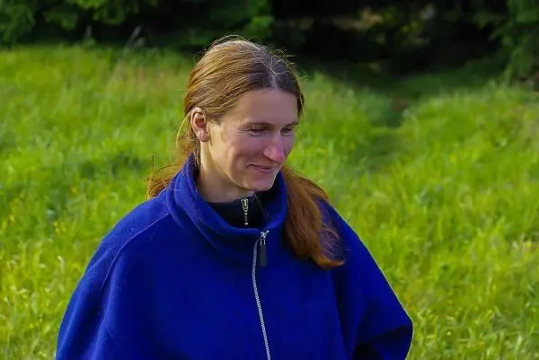 Person steht auf einer wiese und laechelt