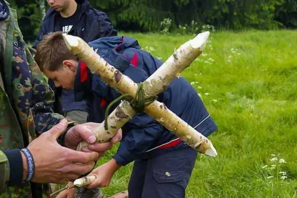 Selbstgebaute Konstruktion aus Ästen wird mit Schnur verbunden