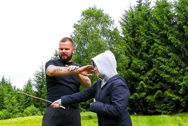 Training mit einem Stock zur Selbstverteidigung im Freien