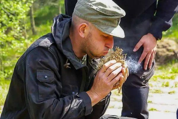 Zunder glimmt, während Luft in das Zundernest geblasen wird