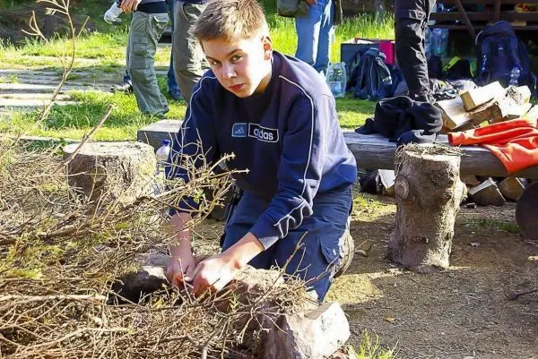 Zunder wird zwischen Steinen vorbereitet, um ein Feuer zu entfachen