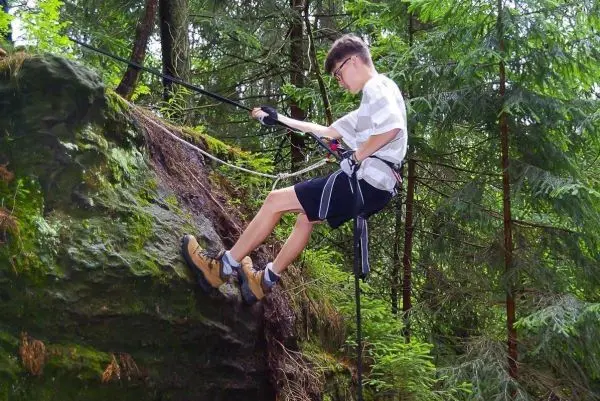 Abseilen an einer Felswand mit Seil und Sicherungsgurt