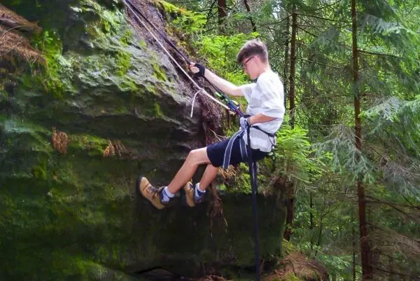 Abseilen an einer Felswand mit Seil und Sicherungsgurt