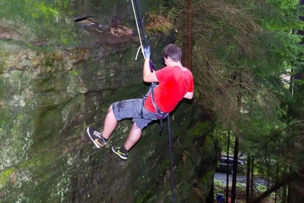 Abseilen an einer Felswand mit Sicherungsseil und Klettergurt