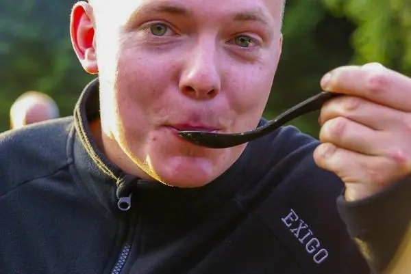 Mann hält einen Löffel und kostet eine Speise