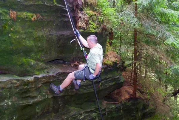 Seilquerung an einer Felswand mit Sicherungsgerät und Kletterausrüstung