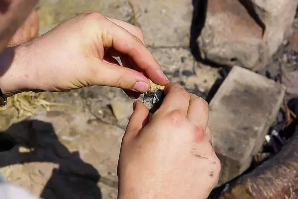 Feuerstahl wird mit einem Schaber bearbeitet, um Funken zu erzeugen