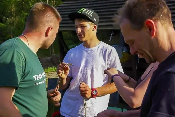 Gruppendiskussion über Holzstücke und Techniken zur Verarbeitung im Freien