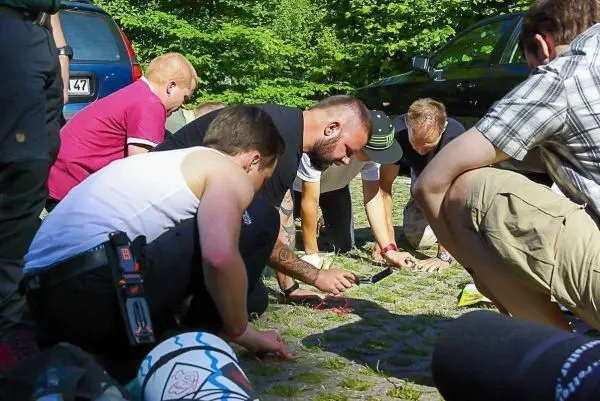 Gruppierung von Personen beugt sich über den Boden und untersucht Materialien