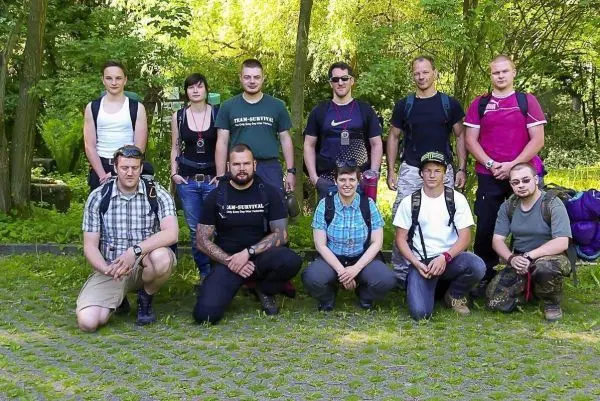 Gruppierung von Personen in Outdoor-Ausrüstung auf einer Wiese