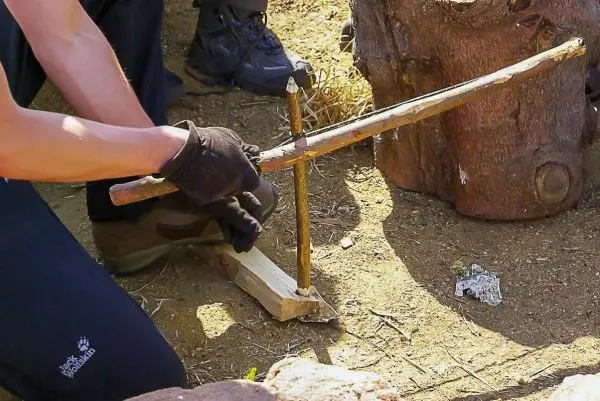 Holzstück mit Kerbe wird für eine Schlagfalle (Figure-Four) vorbereitet