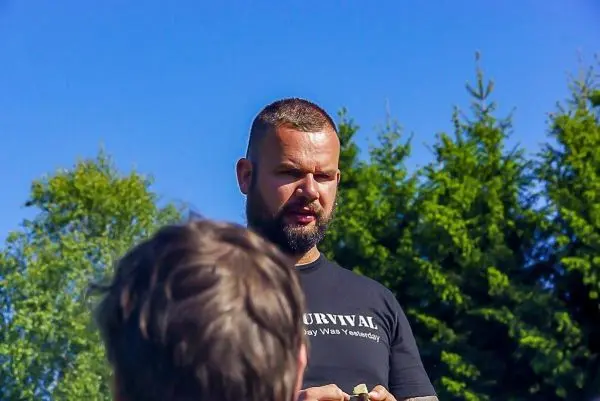 Mann erklärt Survival-Techniken vor einer Gruppe im Freien