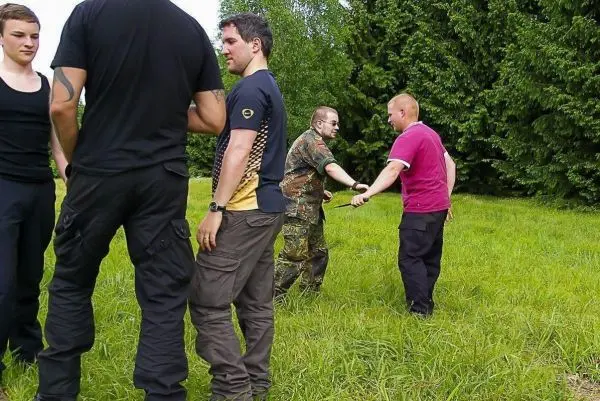 Personen üben eine Technik im Freien auf einer Wiese