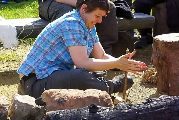 Zunder wird mit einem Feuerbohrer bearbeitet