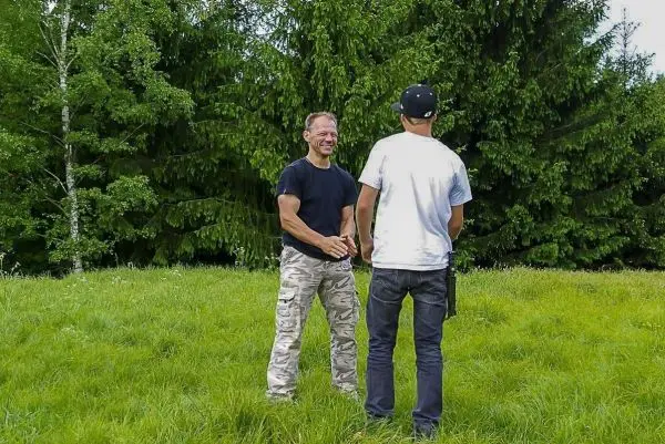 Zwei Personen stehen auf einer Wiese und unterhalten sich freundlich
