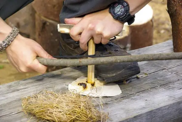 Feuerbohrer erzeugt Glutnest aus Zunder durch Reibung