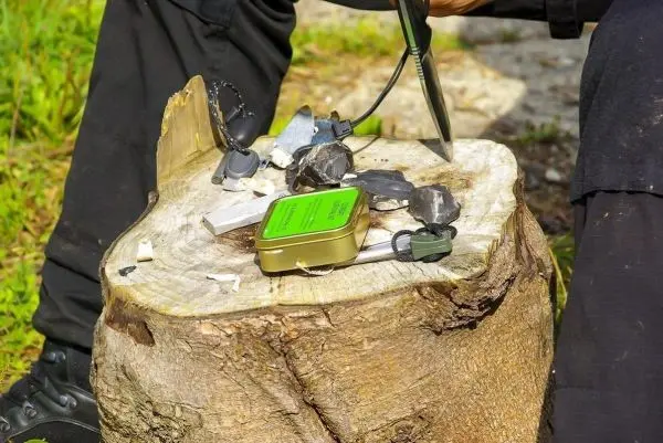 Feuerstahl erzeugt Funken auf Zunder auf einem Baumstumpf