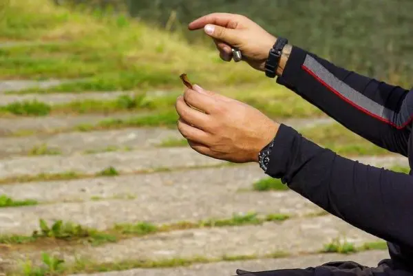 Hände halten einen kleinen Stock, während eine Technik demonstriert wird