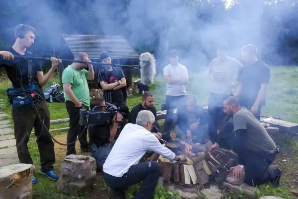 Kleines Bodenfeuer mit Holzscheiten in einer Gruppe umringt