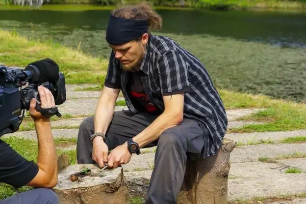Messer bearbeitet Zunder auf einem Baumstumpf am Wasser