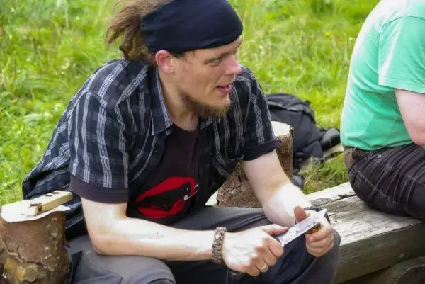 Messer wird auf einem Holzstück gehalten und bearbeitet