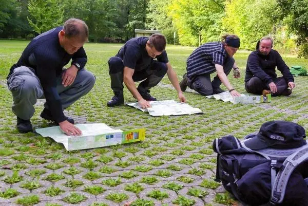 Vier Personen knien auf dem Boden und studieren Karten