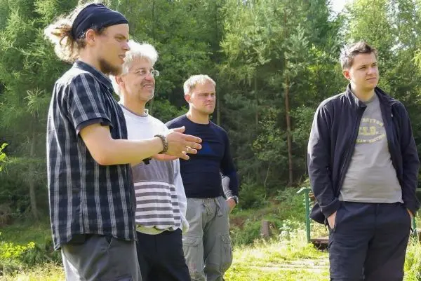 Vier Personen stehen im Freien und diskutieren miteinander