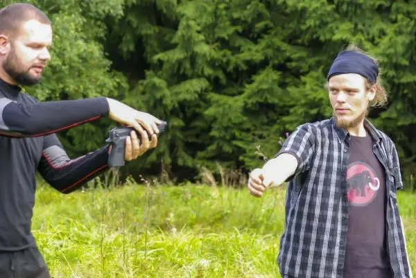 Zwei Personen in einem Feld, eine Person hält ein Gerät in der Hand