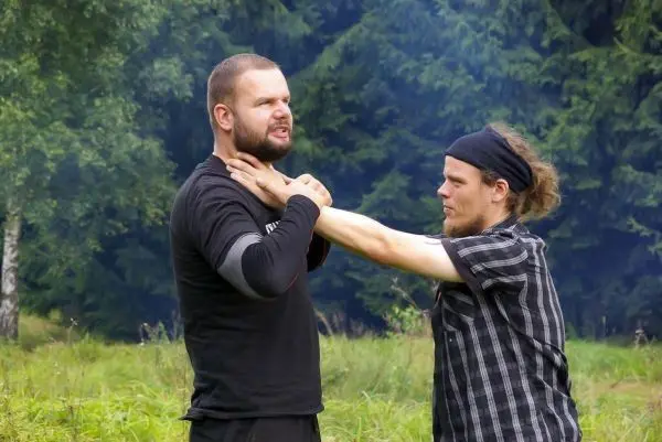 Zwei Personen üben eine Selbstverteidigungstechnik im Freien aus