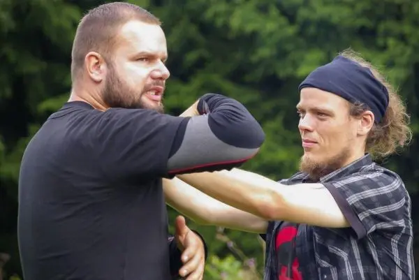 Zwei Personen üben eine Selbstverteidigungstechnik im Freien aus