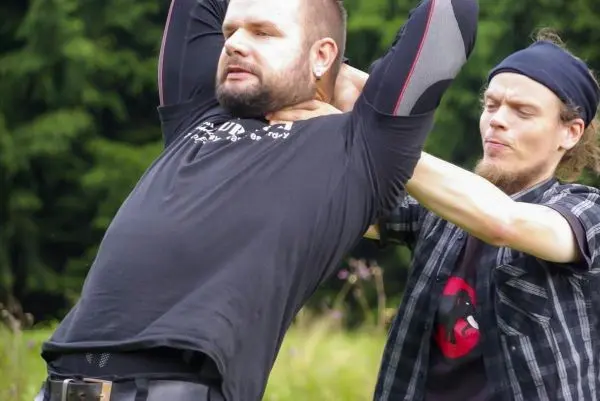 Zwei Personen üben eine Technik zur Kontrolle des Gegners im Freien