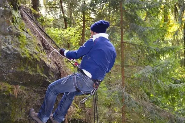 Abseilen an einem Felsen mit Seil und Kletterausrüstung